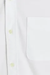 Camisa blanca de vestir de manga larga, cuello abotonado y corte slim fit.