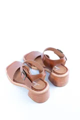 Sandalias de cuero color tostado con tira ancha sobre los dedos, tira al tobillo con hebilla y taco de madera.