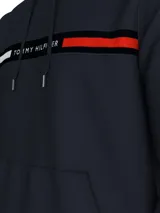 Buzo con capucha y cordón ajustable Tommy Hilfiger, color azul marino, con bolsillo tipo canguro y una franja horizontal en el pecho que incluye texto y los colores distintivos de la marca.