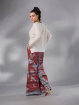 Pantalón de cintura alta y piernas amplias en lino mezcla, con estampado vegetal en tonos bordó, gris y blanco, y tajos asimétricos en las piernas. Cuenta con cierre invisible lateral y bolsillos.