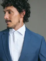 Camisa de vestir de manga larga con cuello clásico y cierre frontal de botones. Presenta un estampado de micro puntos en tonos blanco y azul.