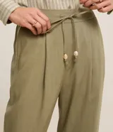 Pantalón fluido Marfinno modelo pijama, color blanco, confeccionado en viscolino. Cuenta con cintura elástica en la espalda, lazo de ajuste, pliegues frontales y bolsillos laterales.