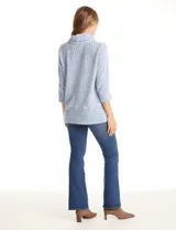 Buzo de tejido velour melange con cuello volcado, mangas tres cuartos y aberturas laterales en el bajo.