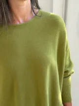 Sweater de punto color verde pistacho, con cuello redondo, mangas largas con puños ajustados y diseño holgado de corte oversize.