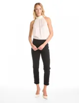 Pantalón de tiro alto con pretina elástica y silueta ajustada. Presenta un diseño tipo pull-on sin cierres, con aberturas laterales en el ruedo decoradas con tres botones metálicos dorados.