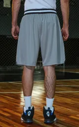 Bermuda deportiva gris con cintura elástica de rayas negras y grises. Estampado frontal con la palabra "RAVERS" y el número "90" en tipografía universitaria negra con borde blanco.