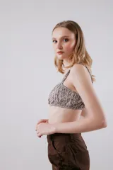 Top tipo bandeau estampado en tonos verde y blanco. Terminaciones y breteles con elástico.