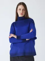 Suéter poncho de cuello alto, corte poncho, mangas largas con terminación acanalada y diseño estampado.