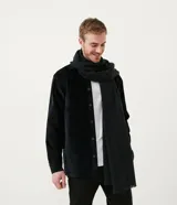 Bufanda larga de tejido suave, color negro, con bordes deshilachados.