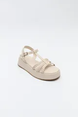 Sandalia de plataforma color marrón con tiras trenzadas y pulsera con hebilla.