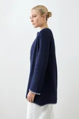 Saco tejido azul marino con pespuntes blancos en cuello, solapa, borde y puños.