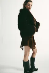 Abrigo corto de Zara confeccionado en pelo sintético de textura suave, color marrón oscuro. Presenta cuello solapa, manga larga y cierre frontal con ganchos metálicos ocultos.