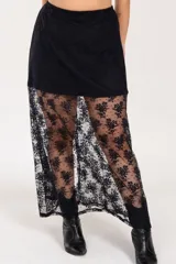 Pollera larga negra con viso, confeccionada en encaje floral. Tiene elástico en la cintura.