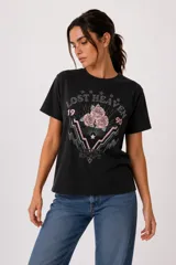 Remera de algodón manga corta, color negro, de corte holgado y cuello a la base. Presenta estampado frontal con rosas rosadas, rayos y leyendas en estilo gráfico con detalles de strass.