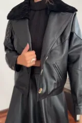 Campera bomber negra de cuero con cuello de piel sintética, forro interior y detalles de pasamanería en cuero marrón gastado.