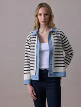 Campera combinada marca Nanette, con torso y mangas en tejido a rayas horizontales blancas y negras. Solapa, puños y cierre en denim celeste. Cierre frontal con botones metalizados.