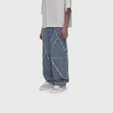 Jean de corte ultra baggy, color azul claro, con costuras con flecos expuestas en el frente y diseño holgado.