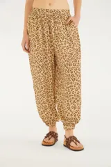 Pantalón babucha de tiro alto con estampado animal print, cintura elástica y puños ajustados en los tobillos. Cuenta con bolsillos laterales.