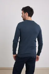 Sweater de punto liso, color azul, con escote redondo y manga larga.