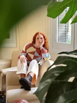 Sweater de punto con diseño geométrico en tonos celeste, marrón y beige.