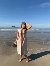 Vestido midi sin mangas color beige, con corte recto y detalle de franja vertical marrón en el centro.