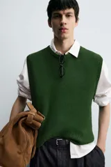 Chaleco de punto color verde oscuro, corte relajado (relaxed fit), con cuello redondo y sisas terminadas en rib.