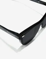 Lentes de sol unisex Hawkers modelo One Venm Raw, con montura cuadrada negra y lentes polarizadas negras.