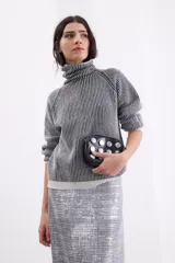 Sweater de cuello tortuga con diseño de rayas verticales en contraste. Presenta mangas largas con hombros caídos y un acabado con sutil brillo de lurex.