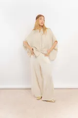 Camisa color crema de lino con mangas amplias y cinta en tono más oscuro en el cuello y la botonadura.