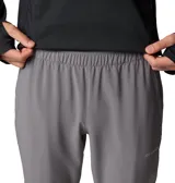 Pantalón técnico de senderismo color gris, con cintura elástica, rodillas articuladas, bolsillos funcionales y cremalleras en los tobillos para mayor comodidad.