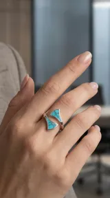 Anillo abierto de plata 925 con diseño geométrico triangular y detalles en piedra turquesa con vetas oscuras.