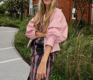 Campera de cuero rosada, silueta oversize y levemente corta. Con cierre frontal metálico, cuello a la base y mangas amplias. Presenta recortes y detalles trenzados en el delantero.