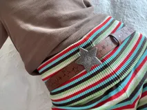 Cinturón marrón de cuero sintético con estrellas grabadas y hebilla plateada en forma de estrella.