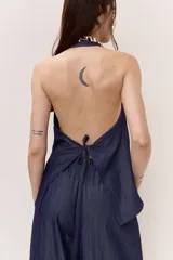 Blusa azul de denim liviano, con escote en V y cuello halter. Cuenta con cierre frontal de botones y diseño suelto de caída fluida.