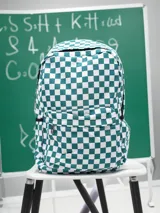 Mochila con diseño a cuadros damero en color verde y blanco, con compartimento principal y bolsillo delantero con cierre.