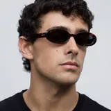 Lentes de sol ovalados con montura carey y lentes verdes oscuros polarizados.