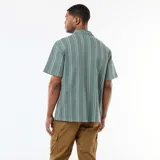 Camisa de manga corta de color verde con diseño de rayas verticales blancas, cuello tipo cubano y cierre frontal con botones.