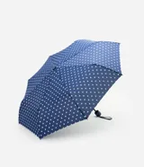 Sombrilla plegable azul marino con estampado de lunares blancos, estructura compacta y asa de muñeca.