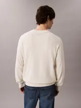 Sweater Calvin Klein de tejido de punto color blanco marfil, con cuello redondo, puños y bajo acanalados, y pequeño monograma CK bordado en el pecho.