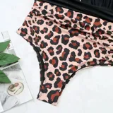 Malla entera combinada con parte superior lisa de color negro, escote halter cruzado y corpiño triangular con copas desmontables. Parte inferior de tiro alto con estampado animal print tipo leopardo.