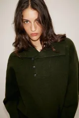Jersey de punto color verde oliva, con cuello solapa y cierre frontal cruzado con botones. De manga larga y corte recto.