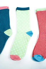Pack de tres pares de medias crew de diseño colorido y estampado variado. Incluye un par a rayas rojas con talón azul y puntera celeste, un par verde claro con lunares blancos, talón azul y puntera rosada, y un par azul con rayas, talón verde claro y puntera celeste.