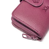 Billetera de tamaño mediano confeccionada en material símil cuero con textura granulada. Presenta un cierre principal, solapa frontal con broche a presión decorado con una flor en relieve y el logo de la marca XL aplicado en el centro.