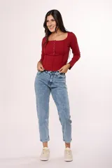 Jean de corte mom con tiro alto, confeccionado en denim de lavado claro con efecto desgastado. Presenta un diseño clásico de cinco bolsillos, cierre con cremallera y botón metálico.