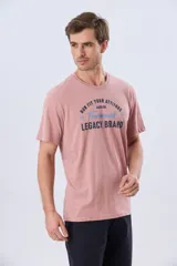 Remera verde pistacho de manga corta y cuello redondo, con diseño gráfico estampado en el frente con inscripciones y tipografías en tonos oscuros y blancos.
