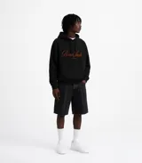 Hoodie color beige con capucha, cordones ajustables y bolsillo tipo canguro. Estampa bordada en el frente con la leyenda "Poona Studio".