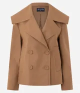 Campera pesada de estructura firme, color marrón, con cuello amplio de solapa alargada, cierre cruzado con botones, mangas largas y bolsillos delanteros. Presenta un canesú sobrepuesto en la espalda con pliegue central.