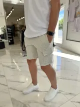 Bermuda cargo de jogging color beige, con bolsillos laterales y cordón ajustable en la cintura.