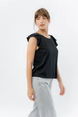 Musculosa rosa de corte clásico con cuello redondo y volados en los hombros.