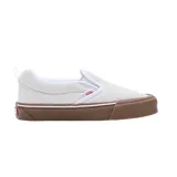 Championes Vans modelo Knu Slip On, de diseño sin cordones, color blanco hueso con suela de goma color marrón. Presentan una silueta robusta con acolchado en el cuello y lengüeta, y el logo de la marca en el lateral.